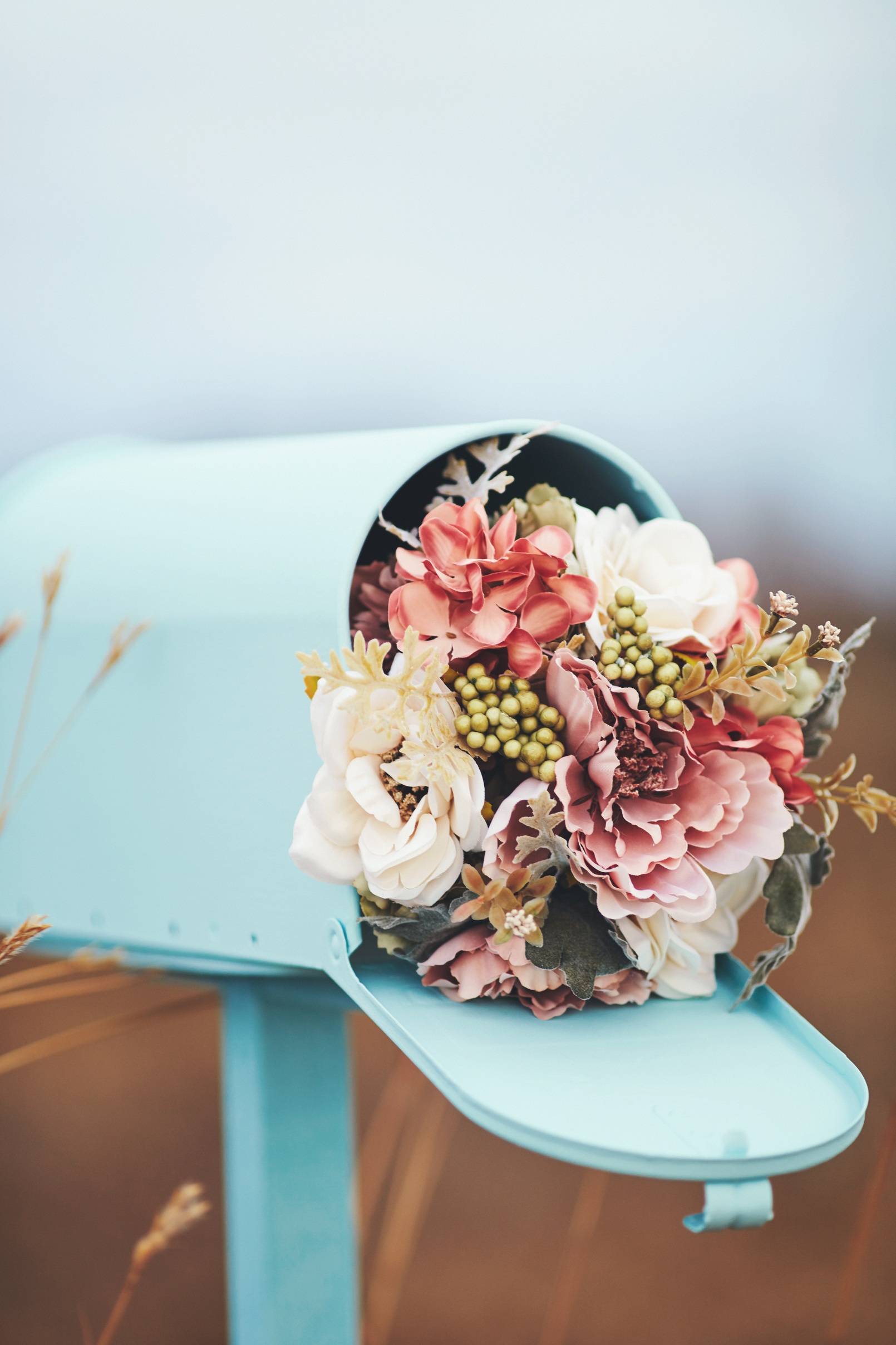 Pastel teal mailbox with bouquet of flowers